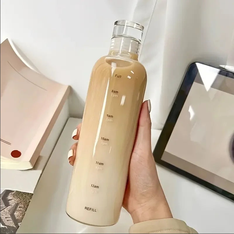 Hand holding a beige water bottle with time markers, next to a book and tablet, Vexo home.