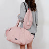 Woman carrying pink Vexo sports duffel bag and matching tennis racket backpack