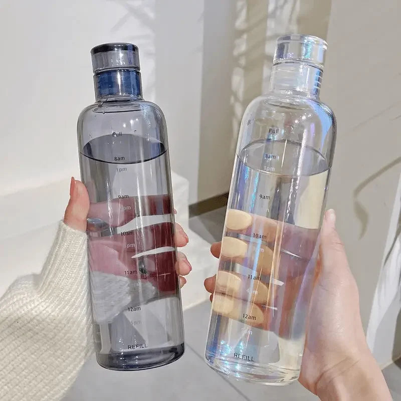 Two clear Vexo water bottles with time markers held in hands, minimalist background